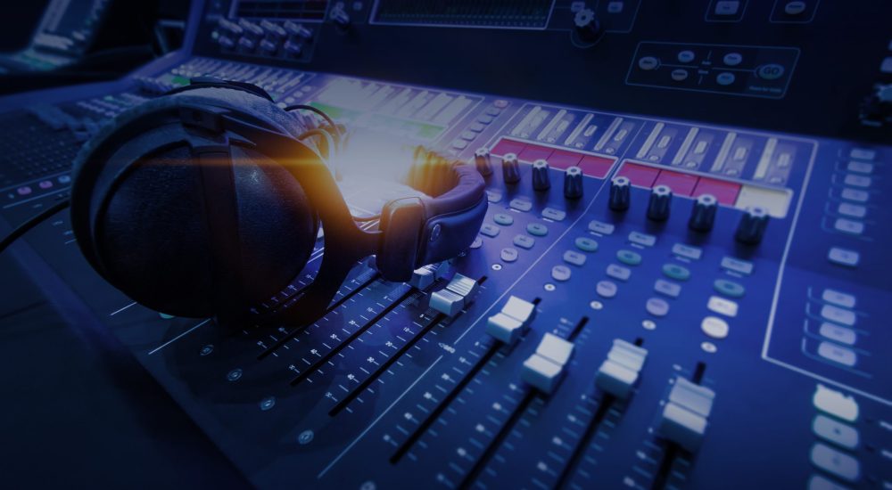 Professional audio studio sound mixer console board panel with recording , faders and adjusting knobs,TV equipment. Blue tone and close-up image with flare light effect.